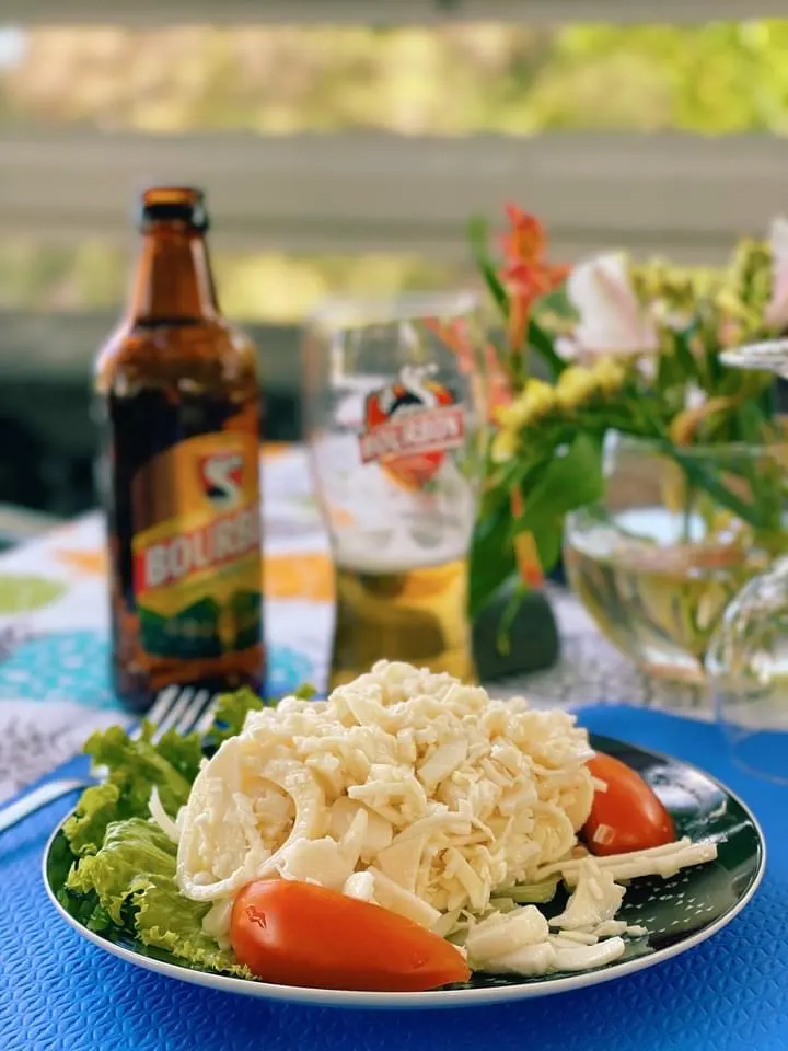 Une assiette servie au Nirvana, avec une bière Bourbon et un bouquet de fleurs sur la table